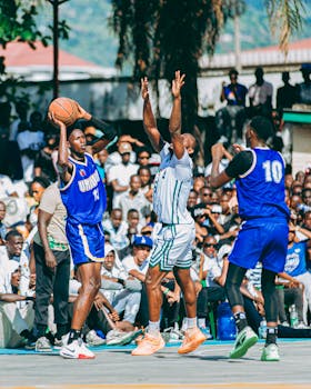 Intense outdoor basketball match with energetic players and a lively crowd.