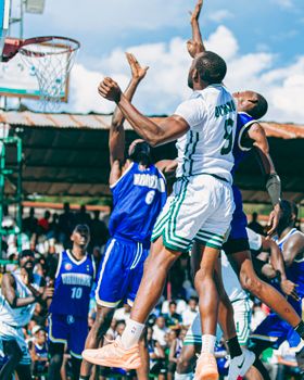 Exciting outdoor basketball game capturing players jumping for the ball under a clear sky.