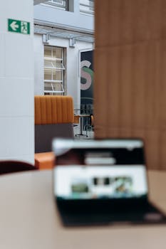 A sleek indoor office with a blurred laptop in focus, offering a contemporary professional vibe.