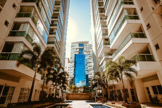 View of modern urban skyscrapers with palm trees, showcasing contemporary architecture.