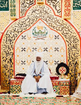 A Nigerian emir sits in a traditional throne room, showcasing African art and culture.