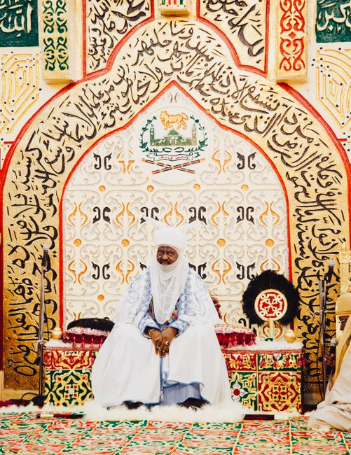 A Nigerian emir sits in a traditional throne room, showcasing African art and culture.