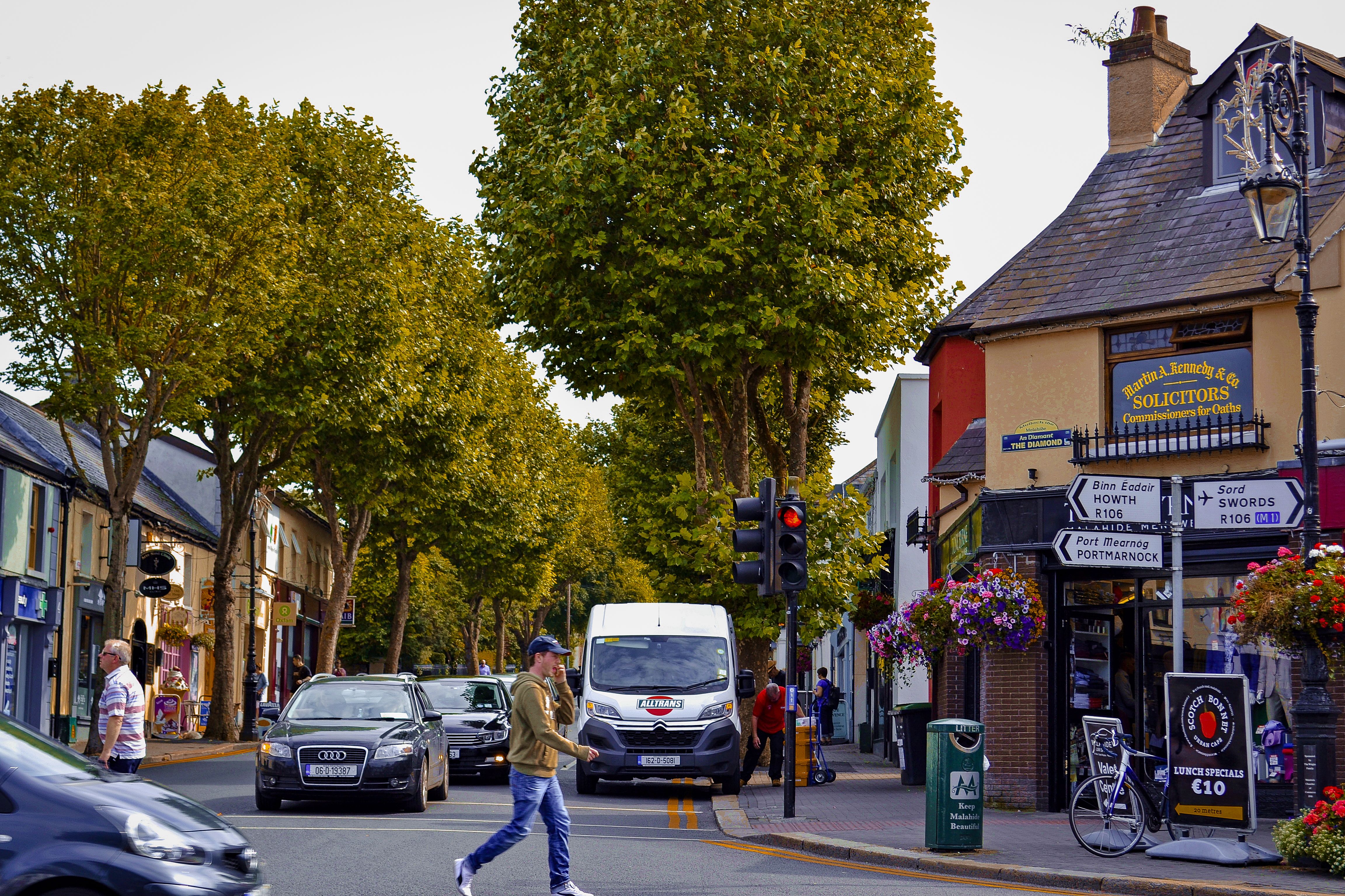 A picturesque street scene in Malahide, Dublin featuring a busy intersection and charming local shops.
