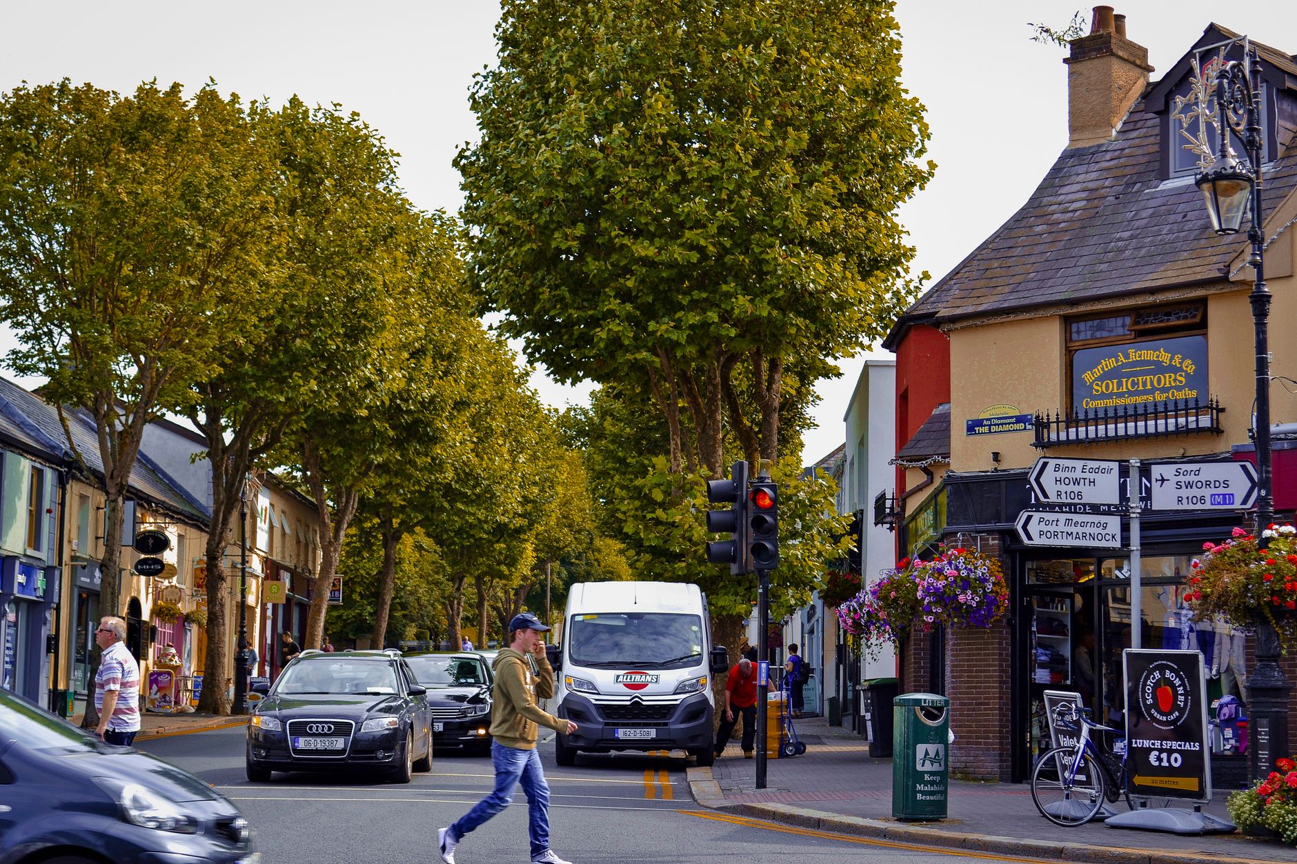 A picturesque street scene in Malahide, Dublin featuring a busy intersection and charming local shops.