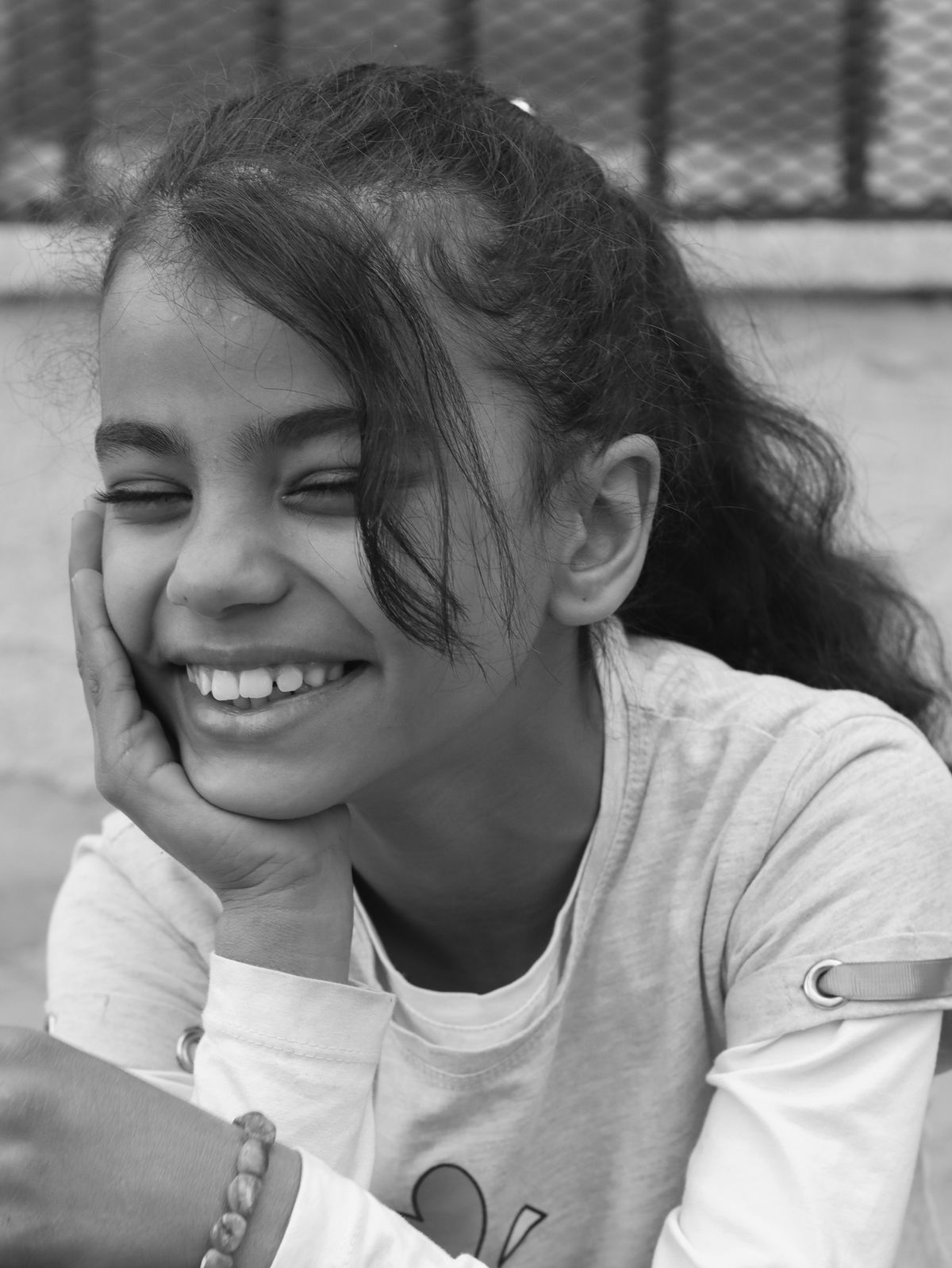 Black and White Portrait of a Smiling Girl Outdoors · Free Stock Photo