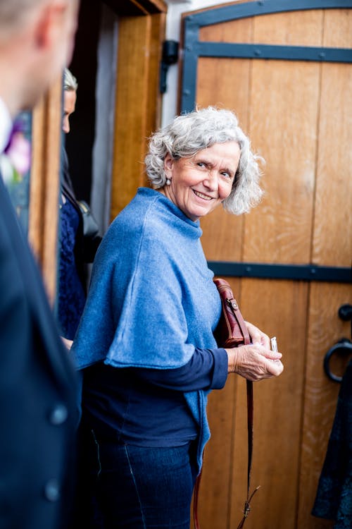 Mujer En Suéter Azul Con Bolso De Cuero Marrón
