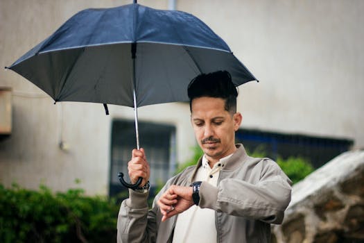 Man holding an umbrella while checking his watch, depicting a rainy day in Collo, Algeria.