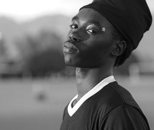 Free Monochrome portrait of a young soccer player with a confident expression on a field. Stock Photo