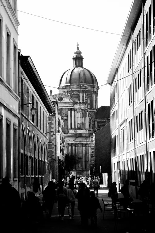 Free Black and white view of a European street leading to a historic cathedral dome. Stock Photo