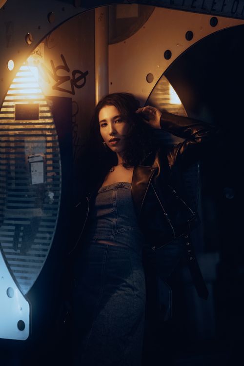 Free Fashionable woman in city night scene with dramatic lighting and urban backdrop. Stock Photo