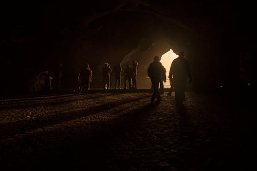 A group of silhouettes in the cave entrance backlit by sunlight in Tangier, Morocco.