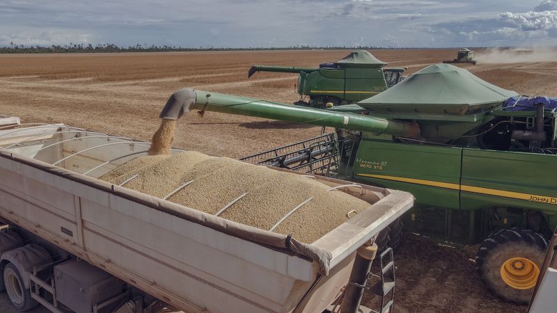 Cosechadora descargando soja en un camión durante la zafra