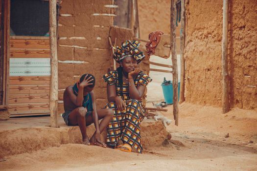 A candid moment showcasing daily life and traditional attire in rural Ghana.
