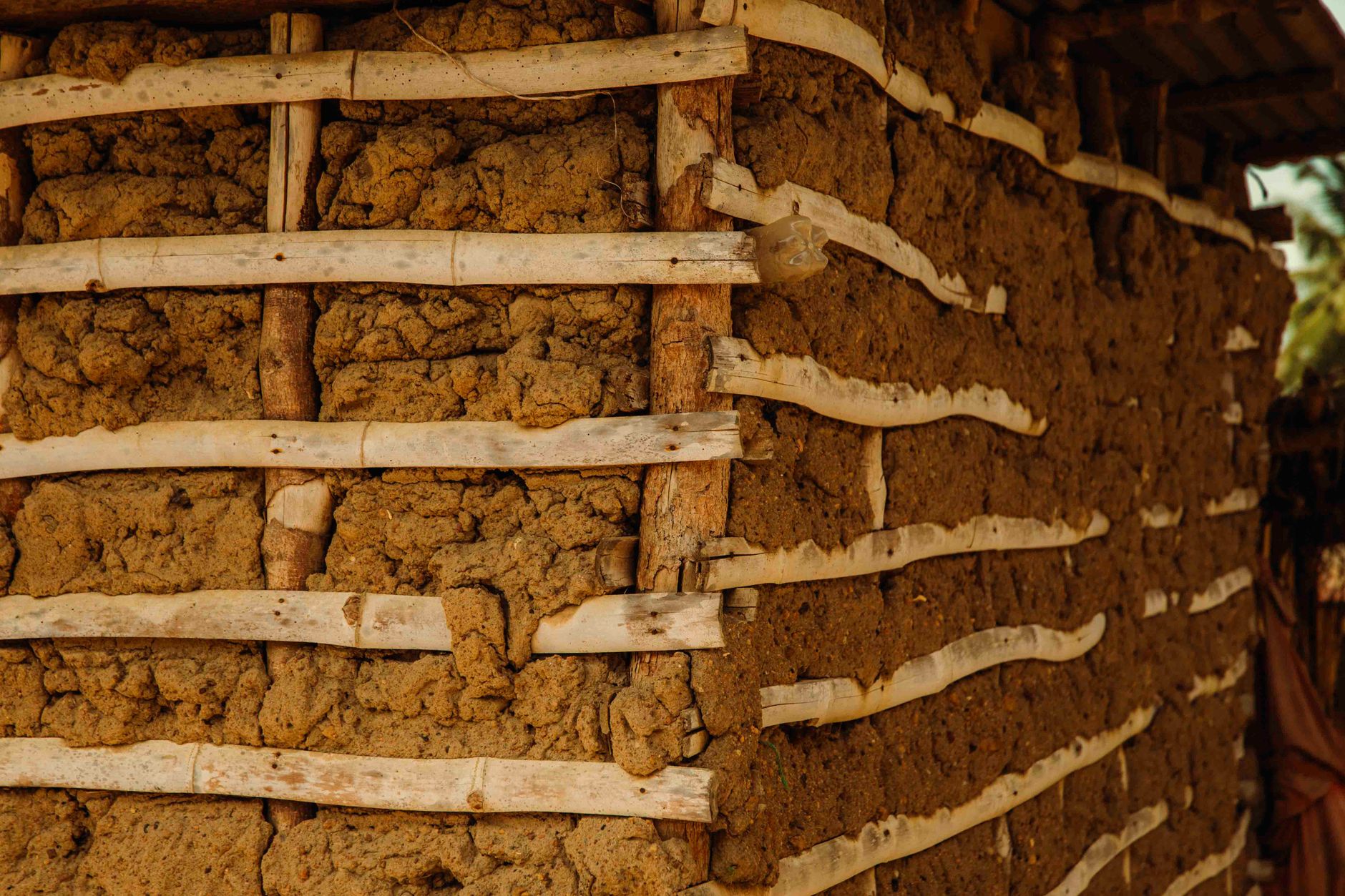 Close-up of a rustic mud house wall in rural Ghana, showcasing traditional architecture.