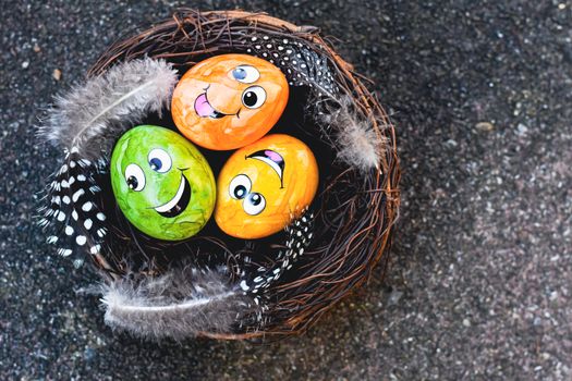 Colorful Easter eggs with happy faces in a decorative nest, perfect for festive celebrations.
