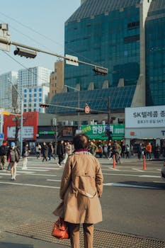 A bustling street scene in Seoul with pedestrians and modern architecture, exemplifying city life.