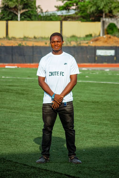 Free Young man in sports jersey stands confidently on a sunny soccer field. Stock Photo