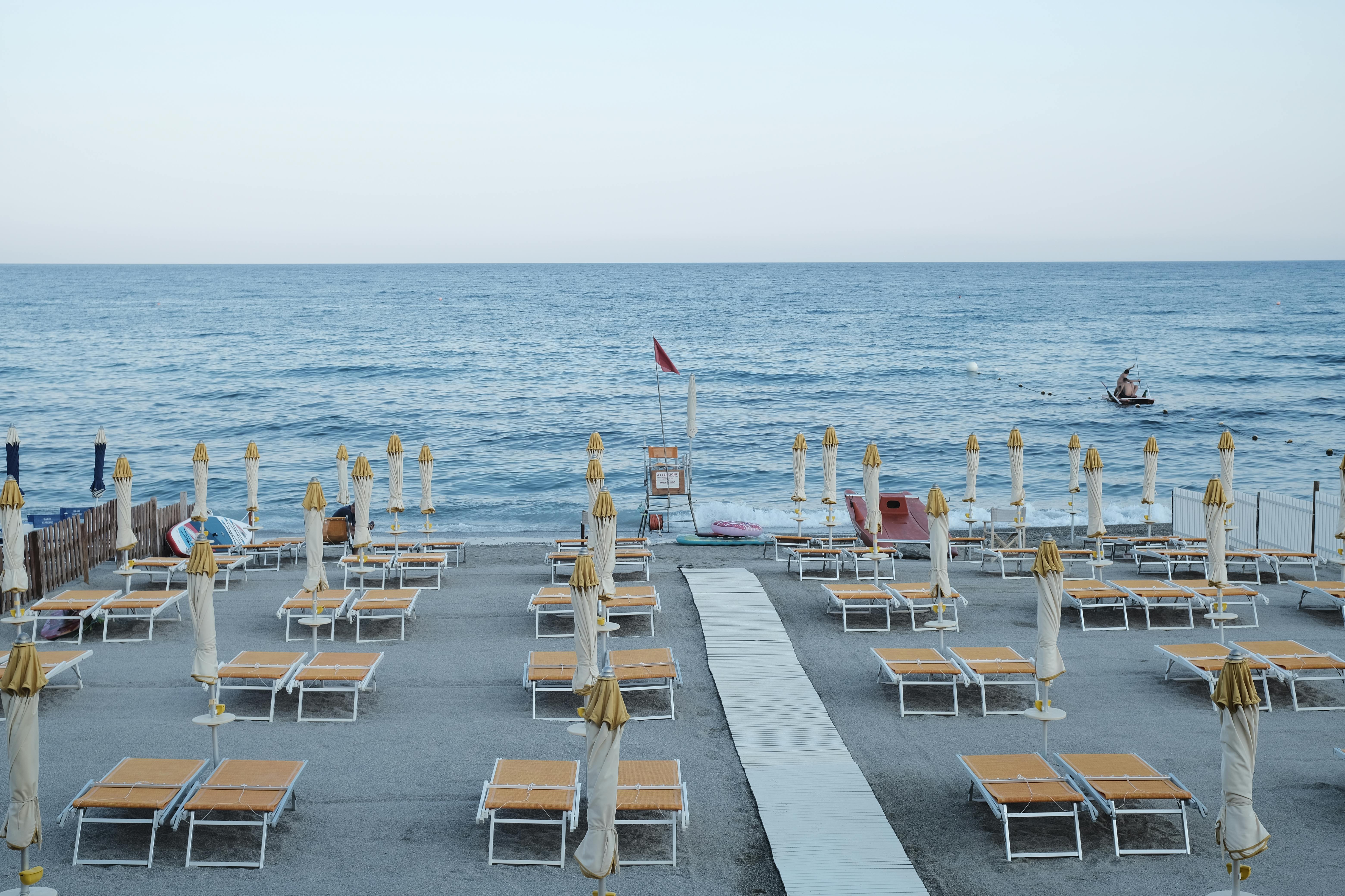 Peaceful Italian beach with empty sun loungers and umbrellas before the crowd arrives.