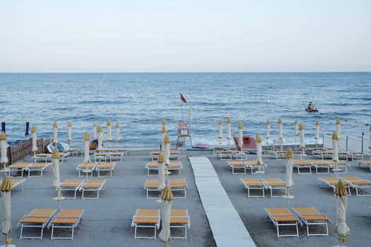 Peaceful Italian beach with empty sun loungers and umbrellas before the crowd arrives.