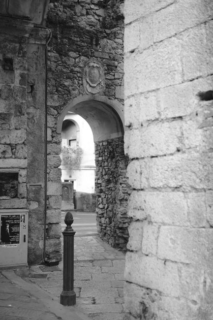 Fotomural Una foto en blanco y negro de un histórico arco de piedra en Italia, capturando la arquitectura intemporal.