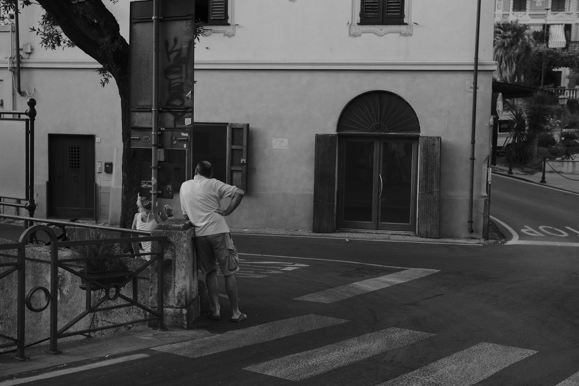 A serene street corner scene featuring an Italian building in grayscale.