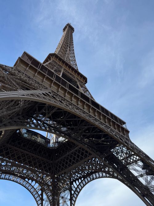 Free Capture of the iconic Eiffel Tower from below against a clear blue sky in Paris. Stock Photo