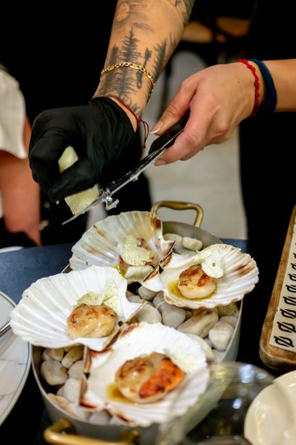 Chef preparing a gourmet scallop dish with exquisite presentation in a fine dining restaurant.