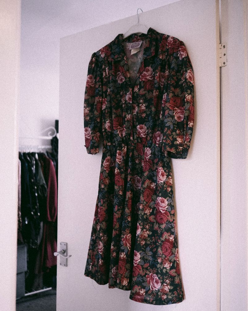 Dress midi motif bunga digantung di dalam lemari dengan cahaya lembut