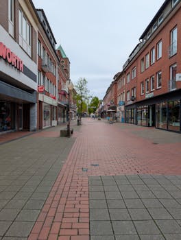 Peaceful empty shopping street in a European city with brick buildings.