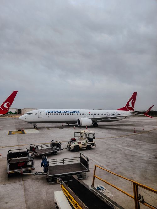 Free Turkish Airlines plane on airport tarmac with logistics equipment, awaiting departure. Stock Photo
