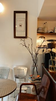 Warm cafe interior with minimalist decor featuring a coffee-themed artwork and cozy seating.