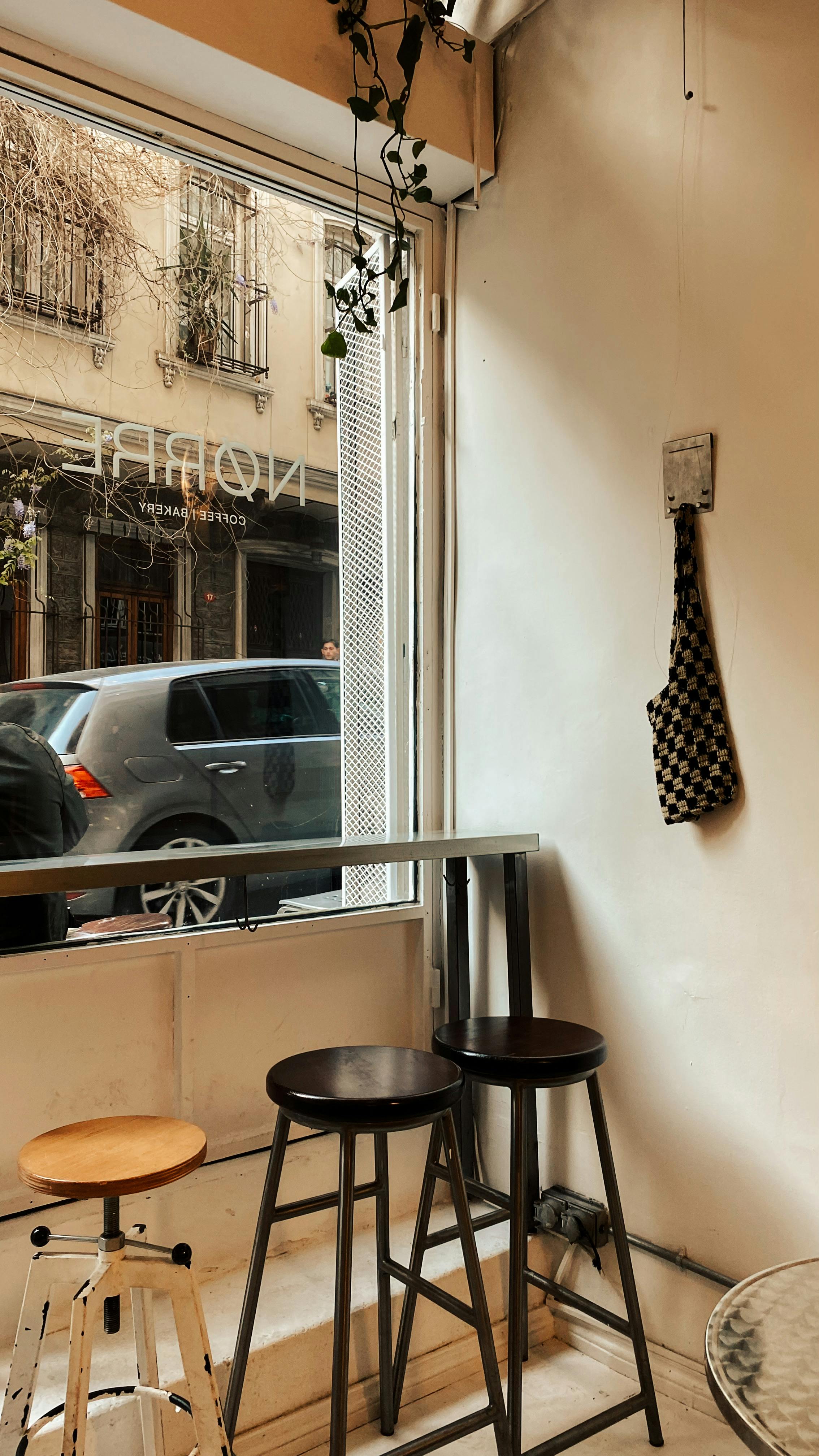 Gratuit Interiorul unei cafenele confortabile cu scaune înalte lângă o fereastră cu vedere la stradă. Fotografie de stoc