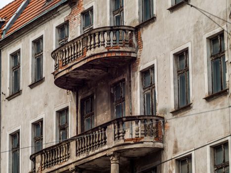 Photography of a historic, weathered building showcasing unique, rustic balconies and architectural details.