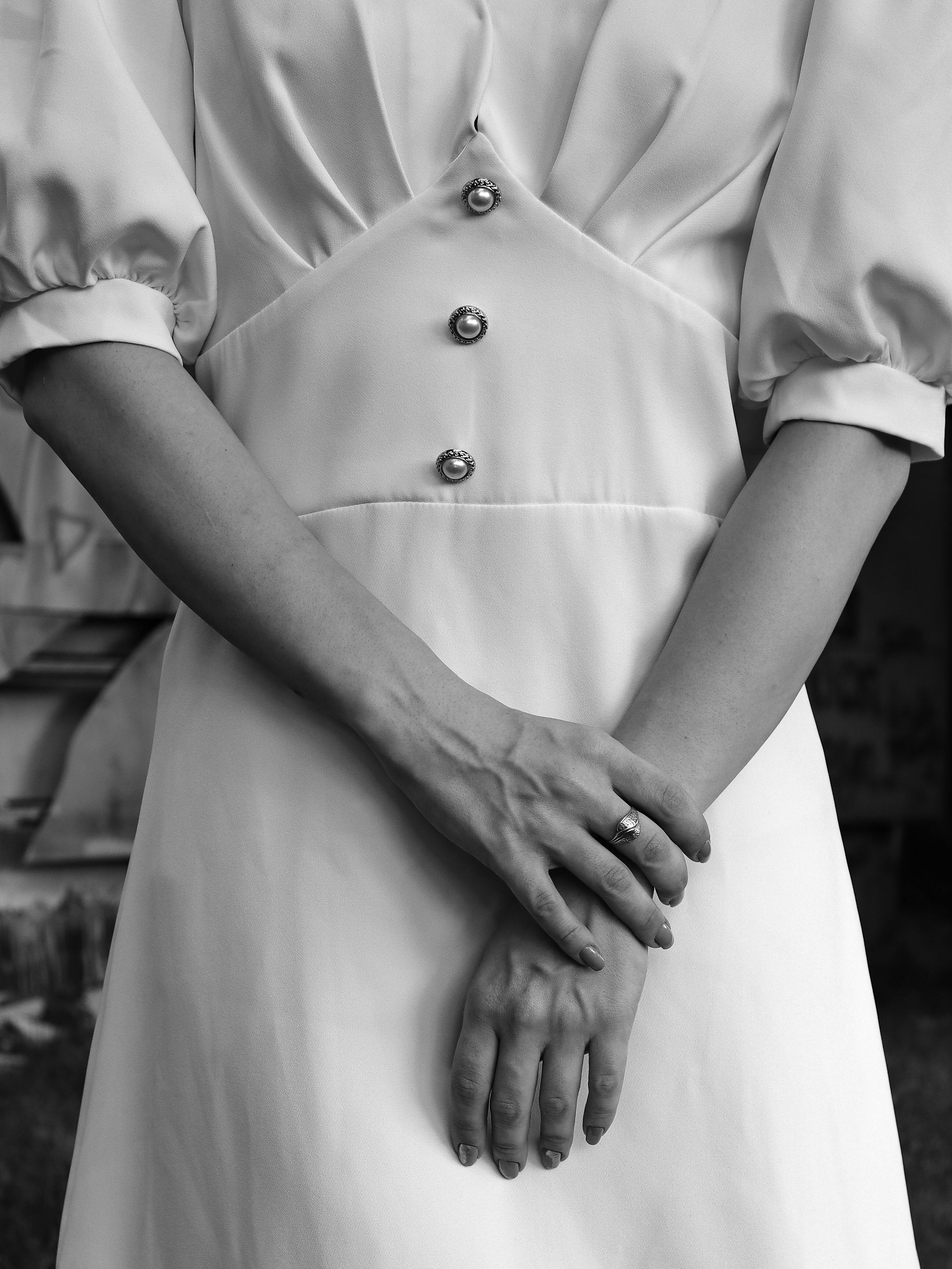 Close-up of a woman's hands in a vintage dress, conveying elegance.