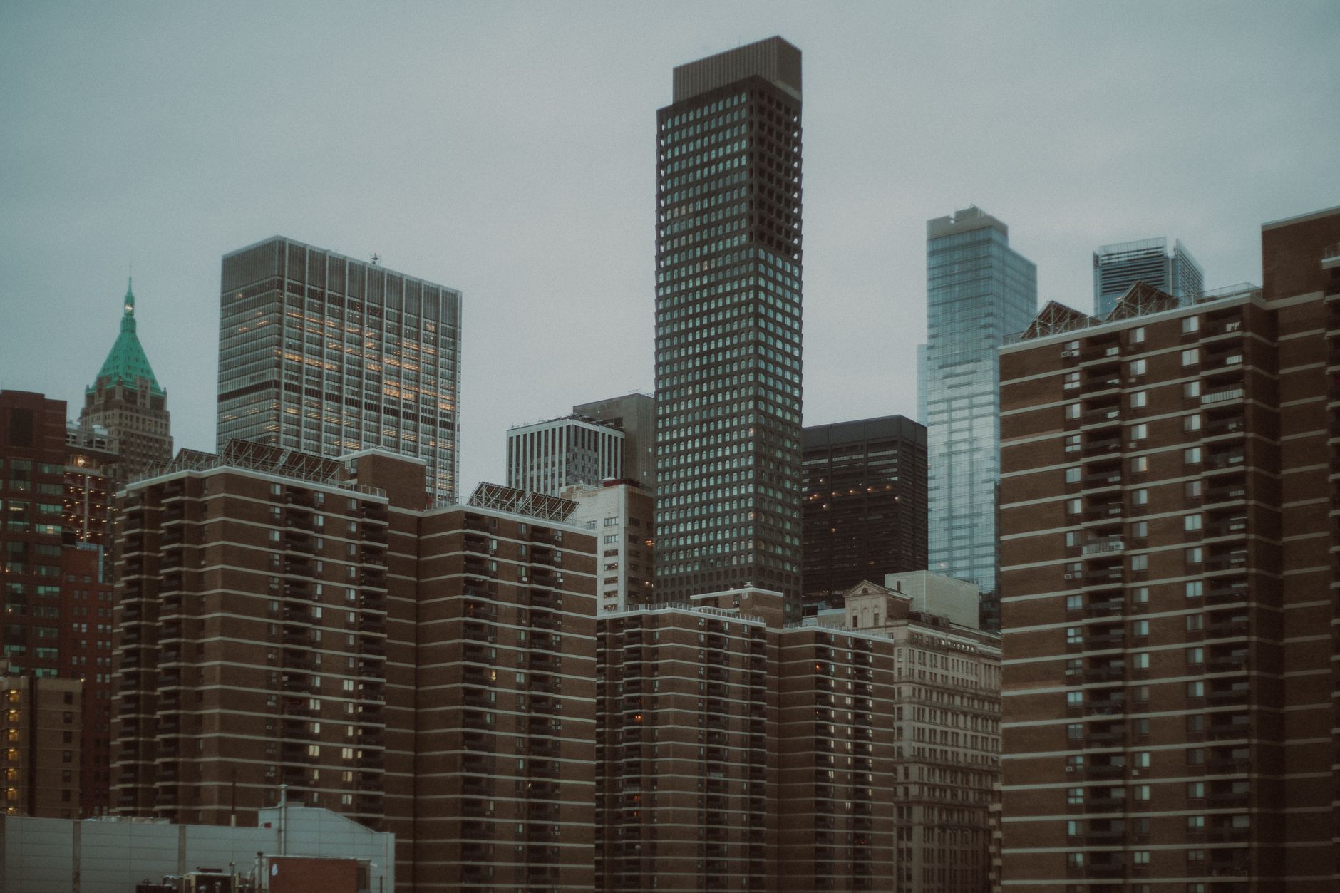 A serene view of New York City's iconic urban skyline with towering skyscrapers under a muted sky.