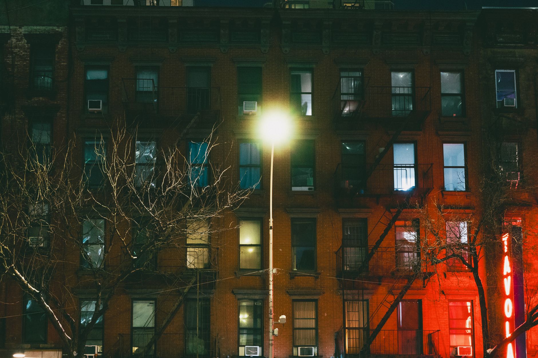 Capture of a dimly lit New York City building facade at night, highlighting urban architecture.