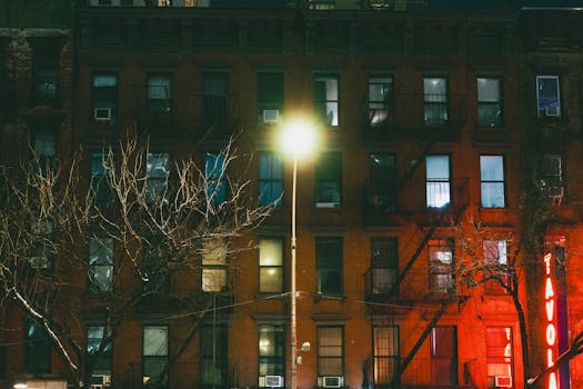 Capture of a dimly lit New York City building facade at night, highlighting urban architecture.