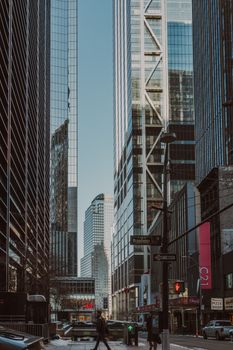 Street-level view of skyscrapers in New York City with a bustling urban atmosphere.