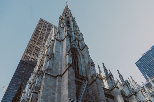 Free St. Patrick's Cathedral and nearby skyscrapers, showcasing Gothic architecture in New York City. Stock Photo