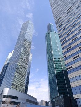 Tall skyscrapers reaching the sky under bright blue weather, showcasing modern architecture.