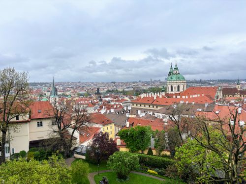 Free Panoramic view of Prague's old town with iconic red roofs and green dome. Captivating urban landscape. Stock Photo