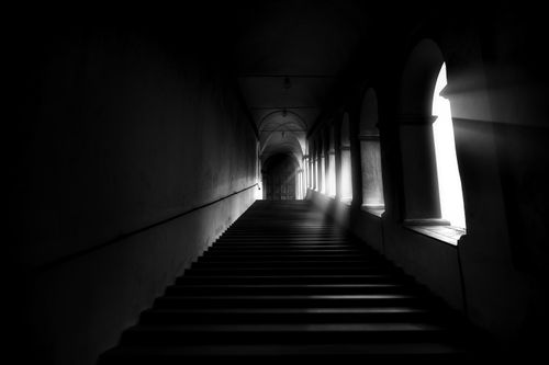 Free Dramatic black and white photograph of a stone staircase, capturing the interplay of light and shadow. Stock Photo