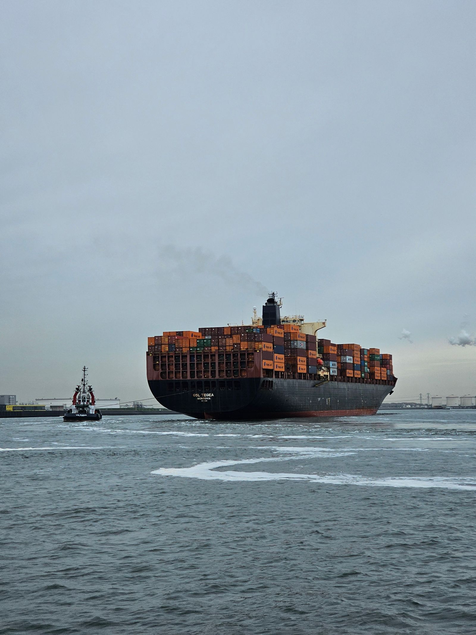 Massive container ship navigating the port of Rotterdam