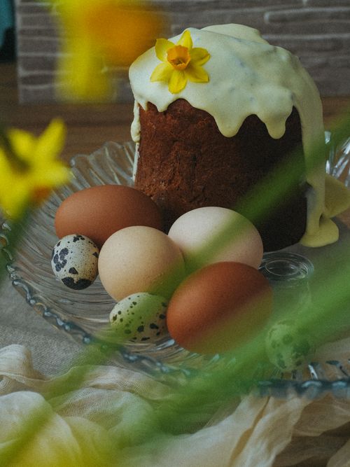 Free Festive Easter cake with icing and eggs on a decorative plate, perfect for spring celebrations. Stock Photo