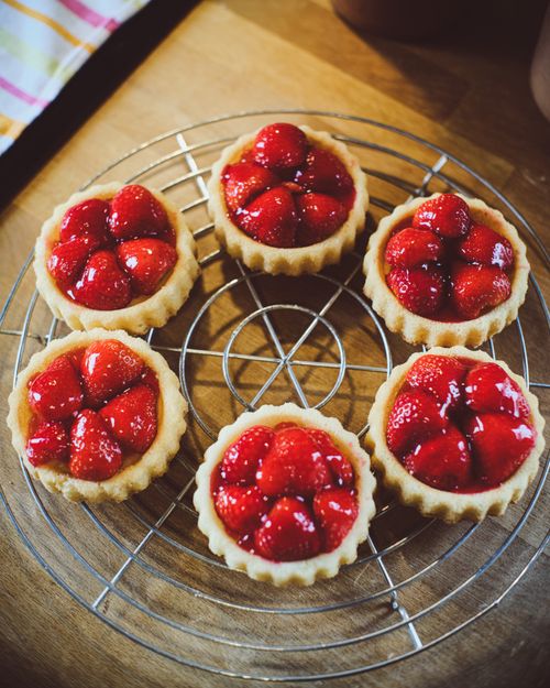 Freshly baked strawberry tarts cooling on a rack — photo by Calvin Seng on Pexels