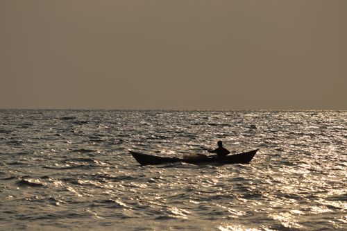 Free A solitary silhouette of a boat against the shimmering sea at sunset in Gokarna, India. Stock Photo