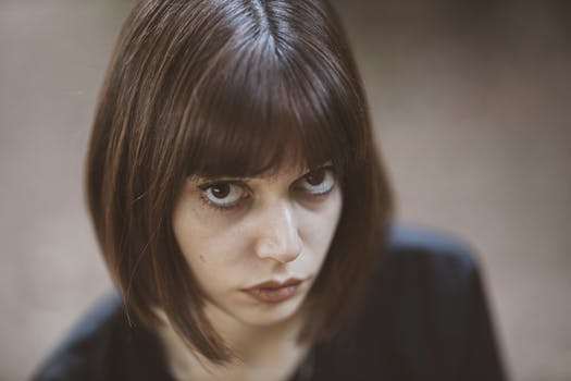 Close-up of a young woman with intense gaze and stylish bob haircut.