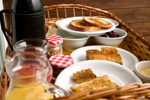 Free A beautifully arranged breakfast basket with toast, fruit, and drinks, perfect for a cozy meal. Stock Photo