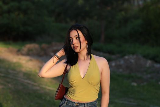Young woman enjoying sunny day outdoors in stylish summer attire.