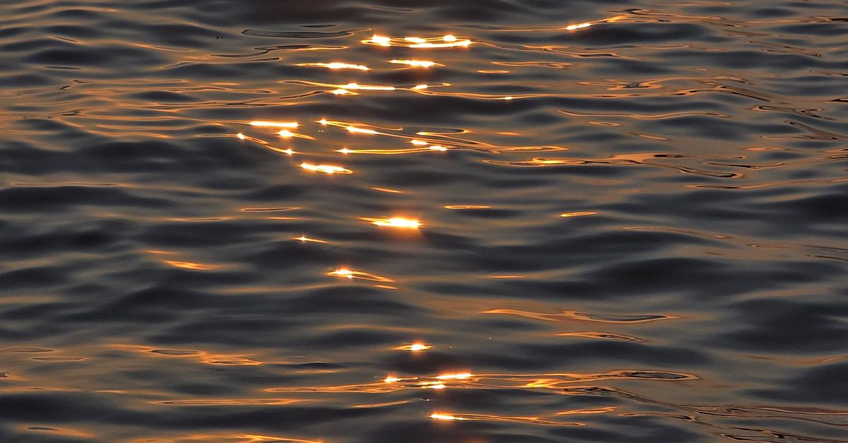 Reflective Ocean Sunset Reflection on Calm Ocean Waters · Free Stock Photo
